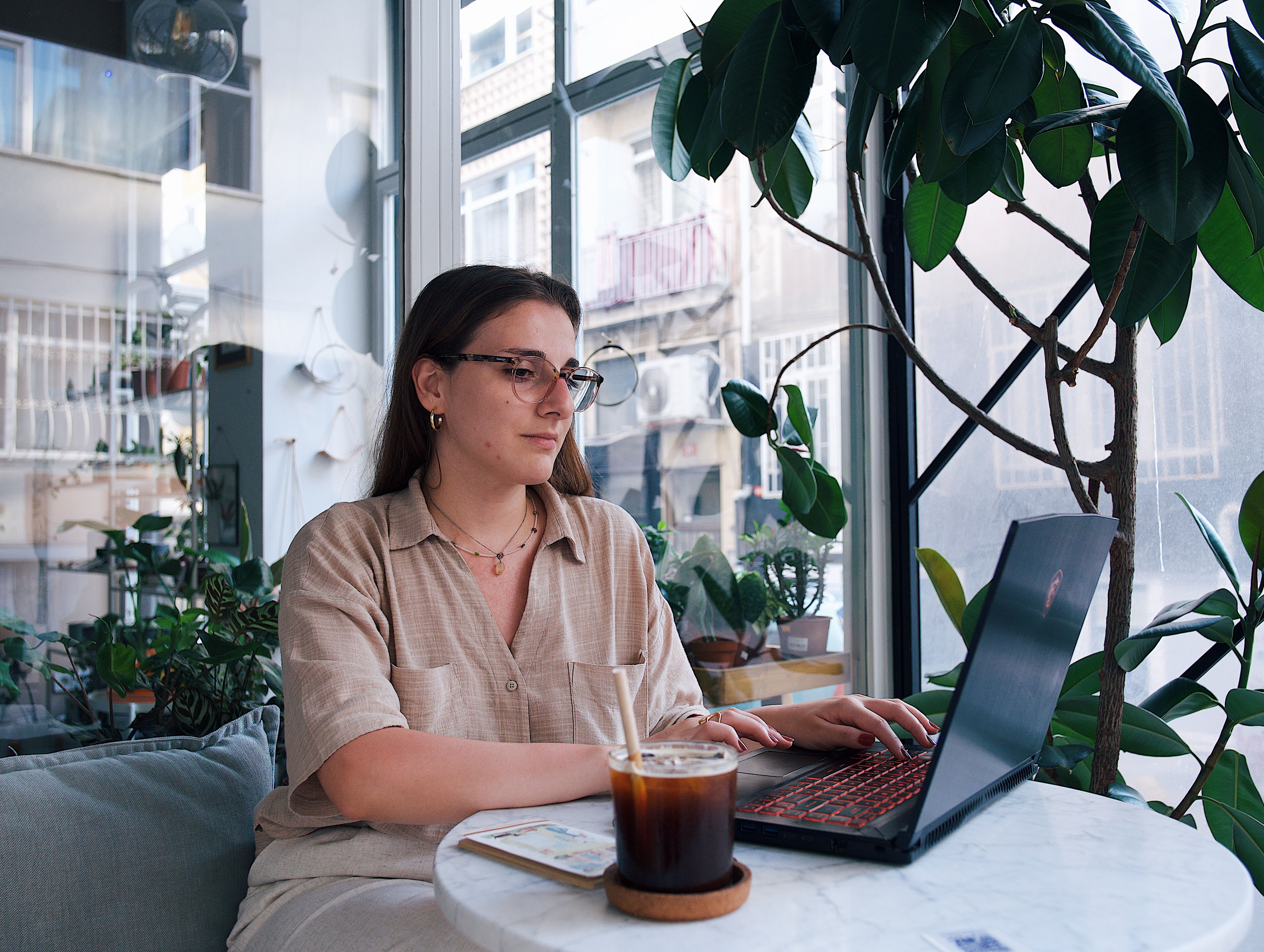 Woman with glasses at indoor café with plants